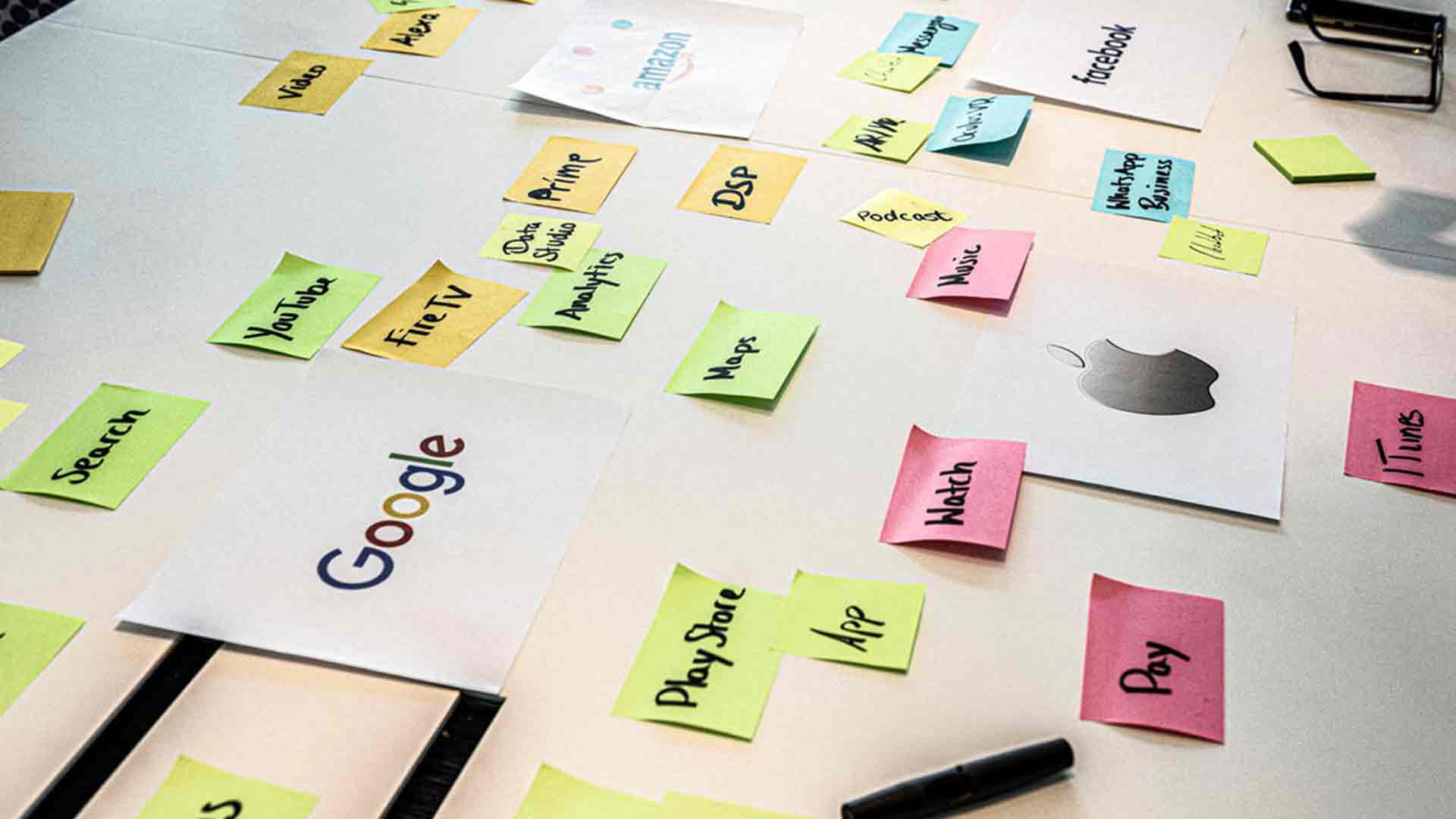 Ausgedruckte Bilder und bunte Haftnotizen mit Marketing-Begriffen